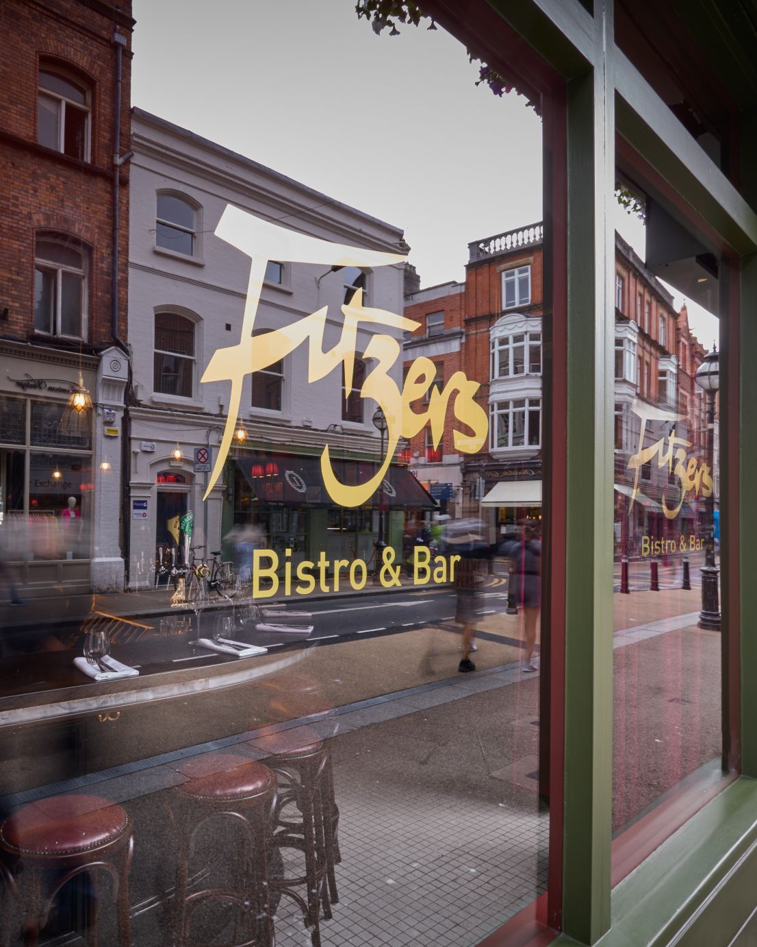 Fitzers Bistro & Bar | View from Exchequer Street, Dublin The gold 'Fitzers Bistro & Bar' logo on the front window, with a view looking out onto the bustling Exchequer Street in Dublin.
